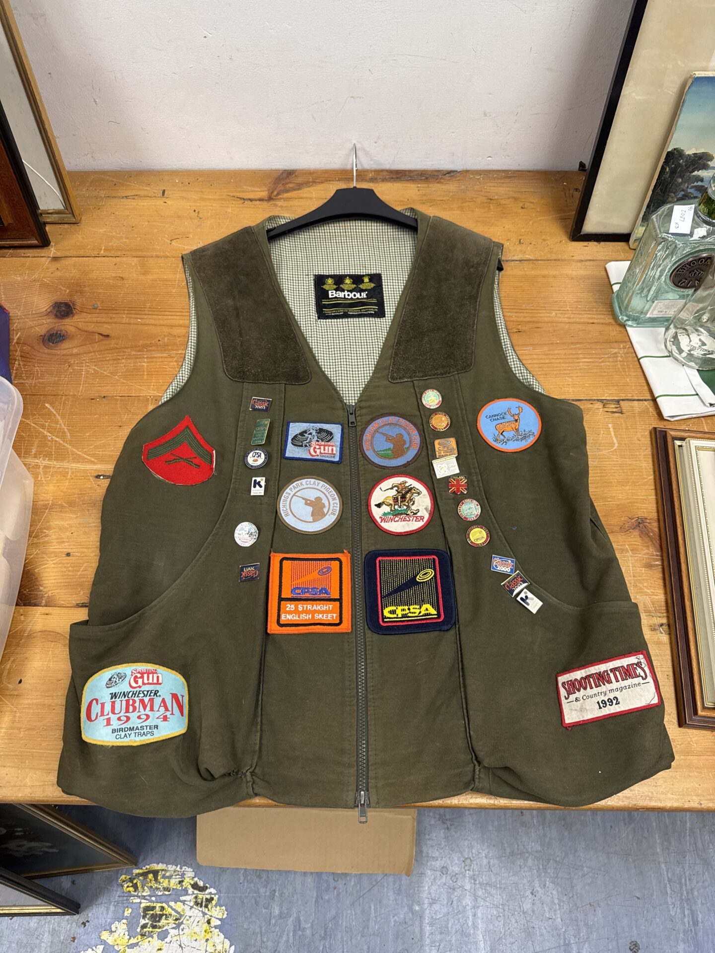 Vintage Barbour shooting gilet with colourful enamel badges.