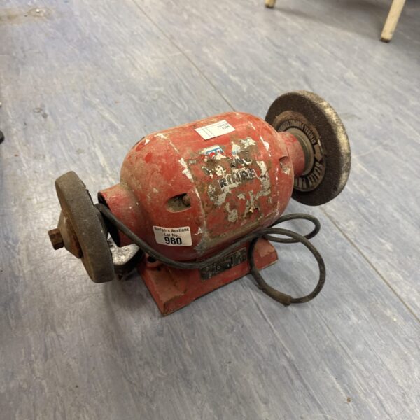 Vintage bench grinder with two wheels, ideal for workshop use.