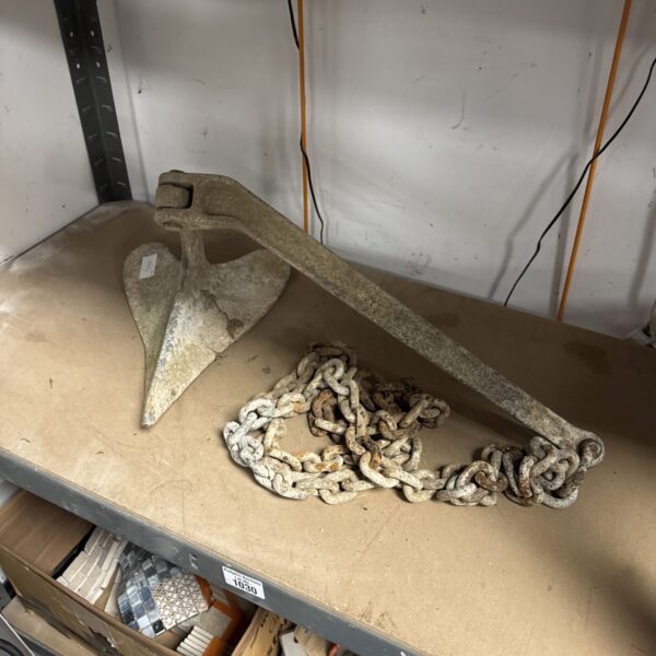 Vintage boat anchor with heavy chain for nautical decor.