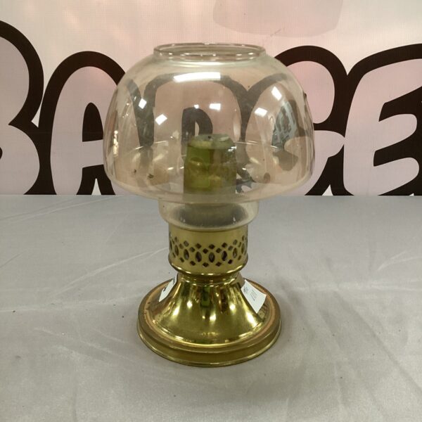 Vintage brass candle holder with clear glass shade and spring mechanism.