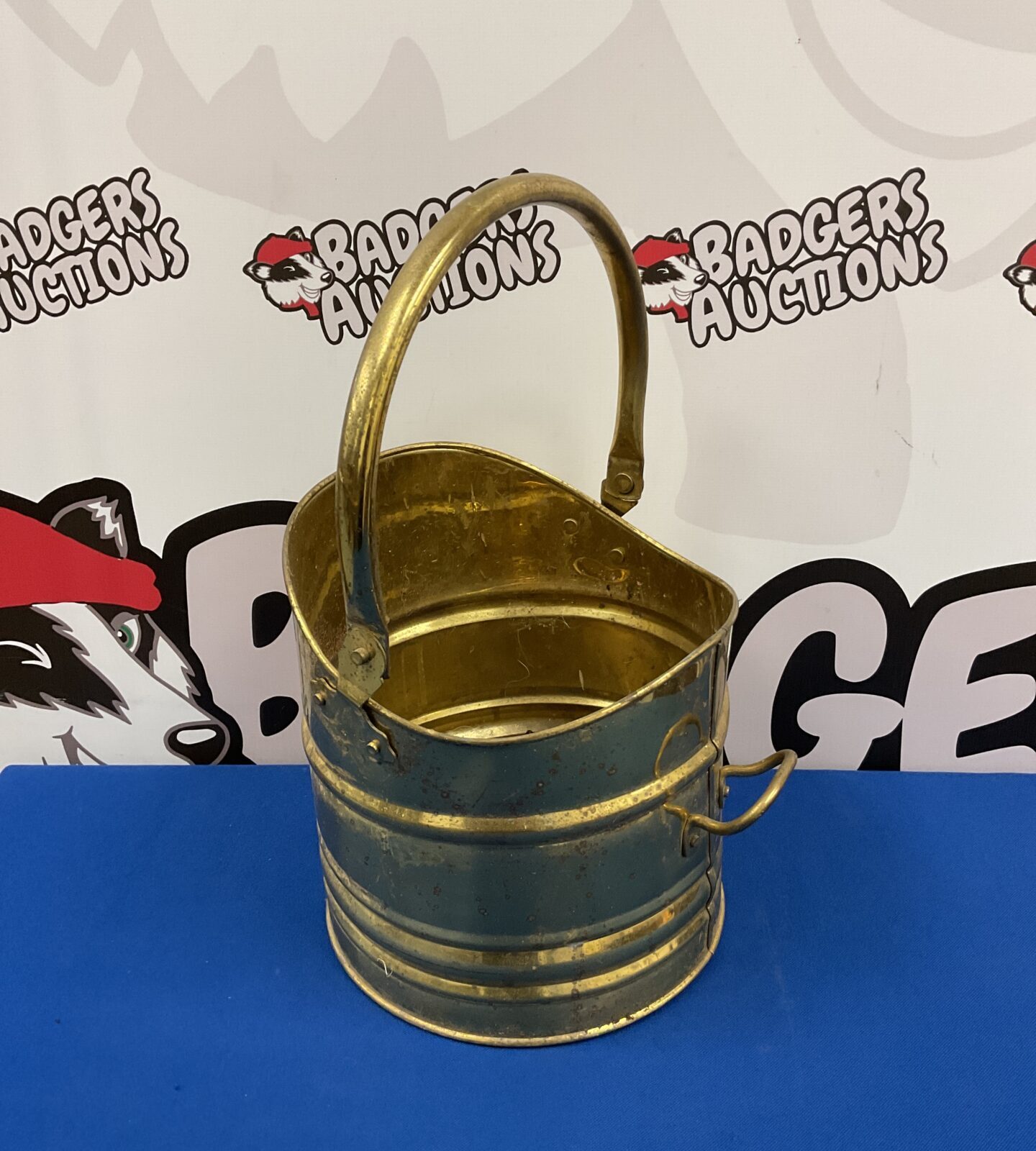 Vintage brass coal scuttle with handle, antique fireplace accessory.