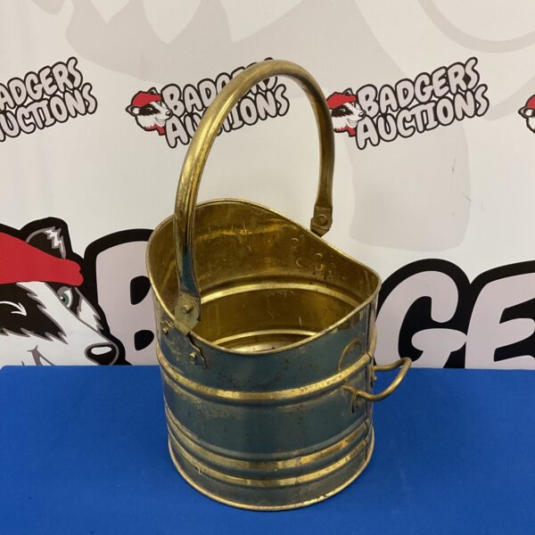 Vintage brass coal scuttle with handle, antique fireplace accessory.