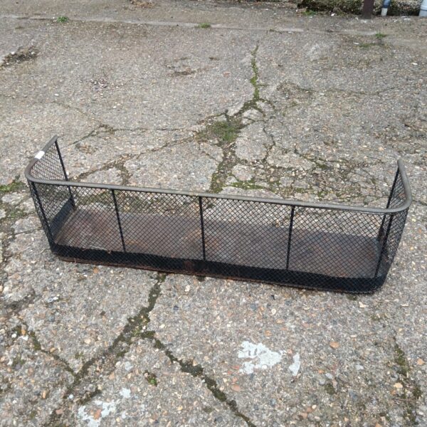 Vintage brass mesh fireplace fender for hearth protection.