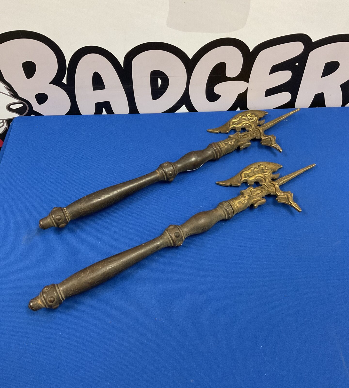 Pair of vintage brass wall axes with ornate detailing.