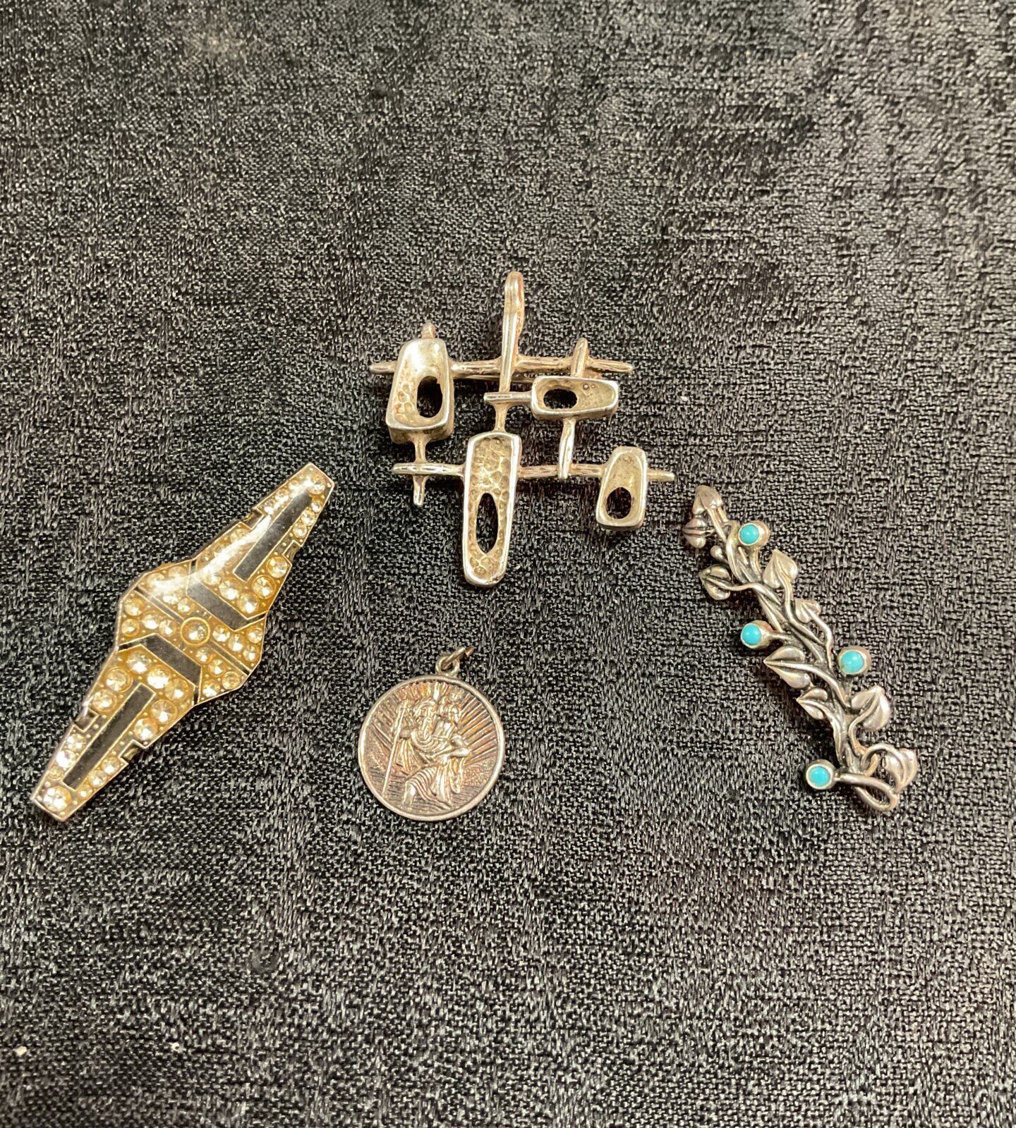 Vintage brooch lot with whitemetal designs and silver pendant.