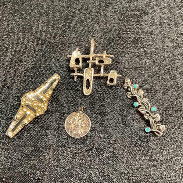 Vintage brooch lot with whitemetal designs and silver pendant.