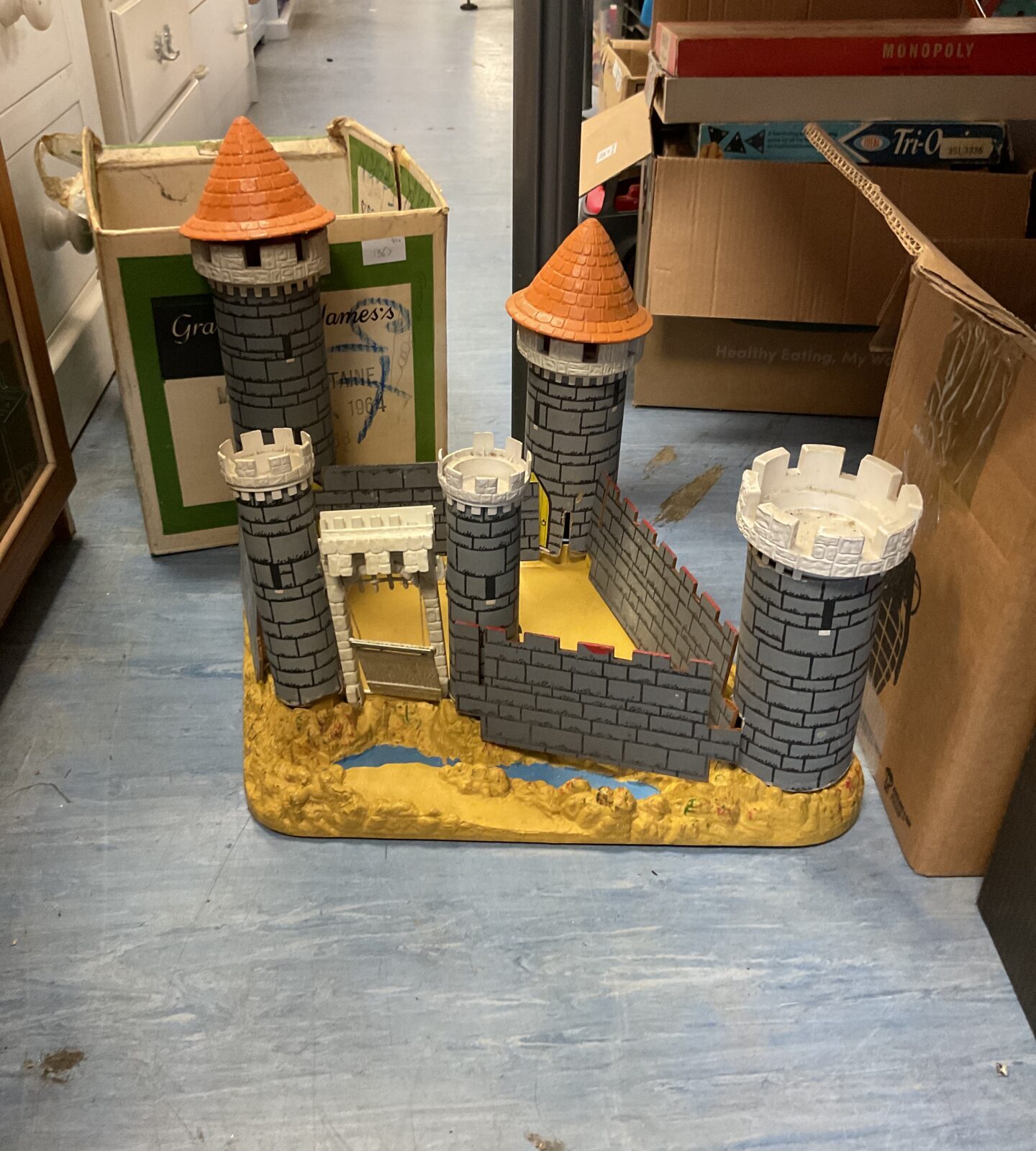 Vintage cardboard castle playset with colourful plastic turrets.