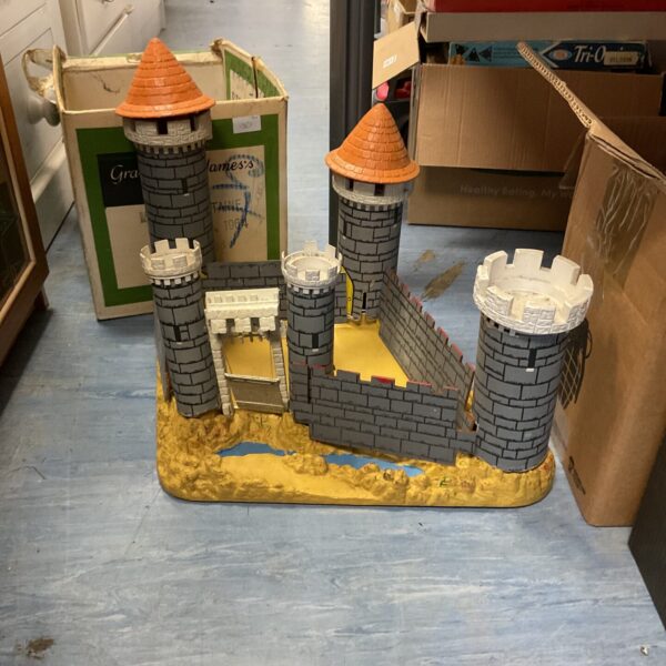 Vintage cardboard castle playset with colourful plastic turrets.