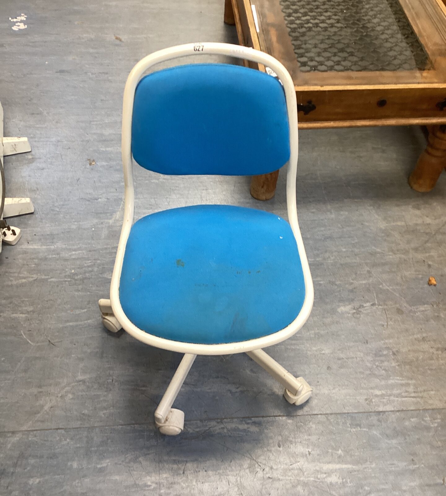 Bright blue vintage child's swivel chair on caster wheels.