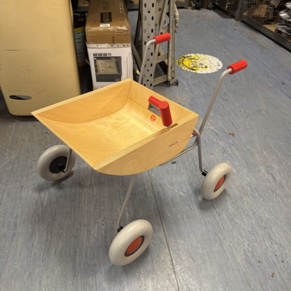 Vintage Sirch child’s wheelbarrow with red handles and grey wheels.