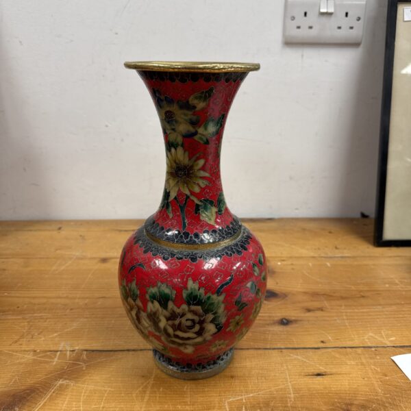 Vintage cloisonne vase with floral design and red background.