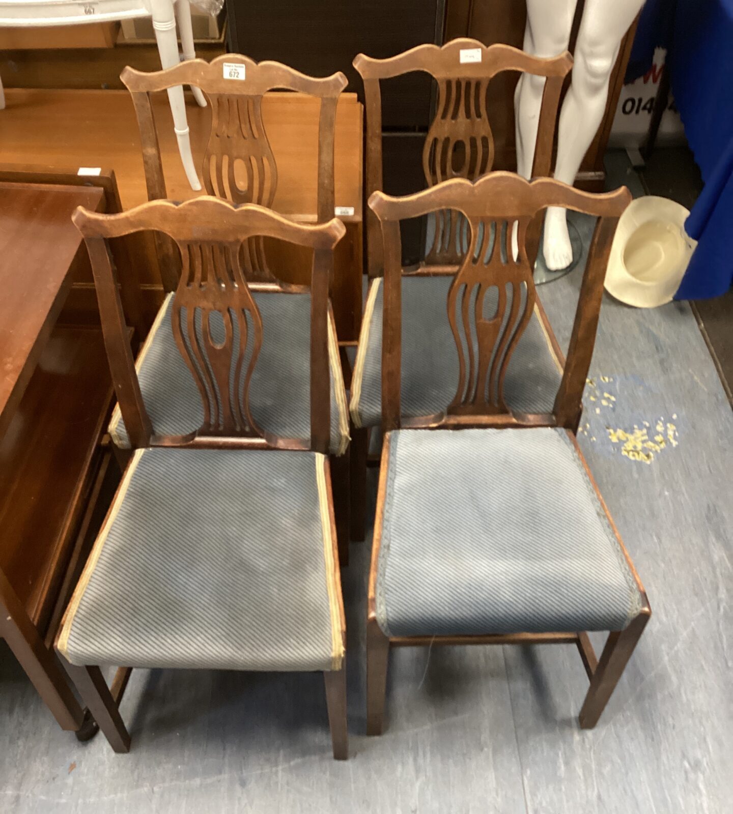 Set of four vintage wooden dining chairs with upholstered seats.