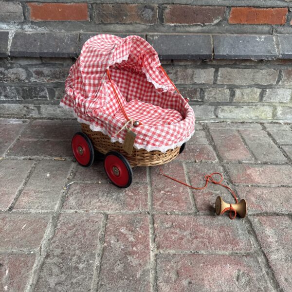 Vintage wicker dolls pram with gingham lining.
