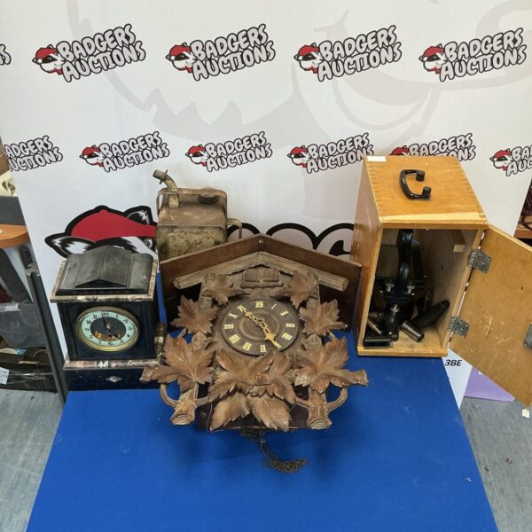 Detailed vintage double cuckoo clock with accompanying items.