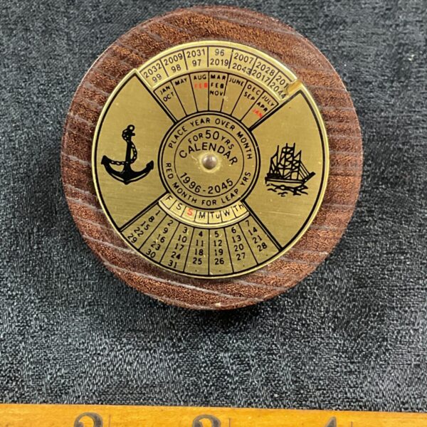 Vintage fifty year desk calendar with rotating dials.