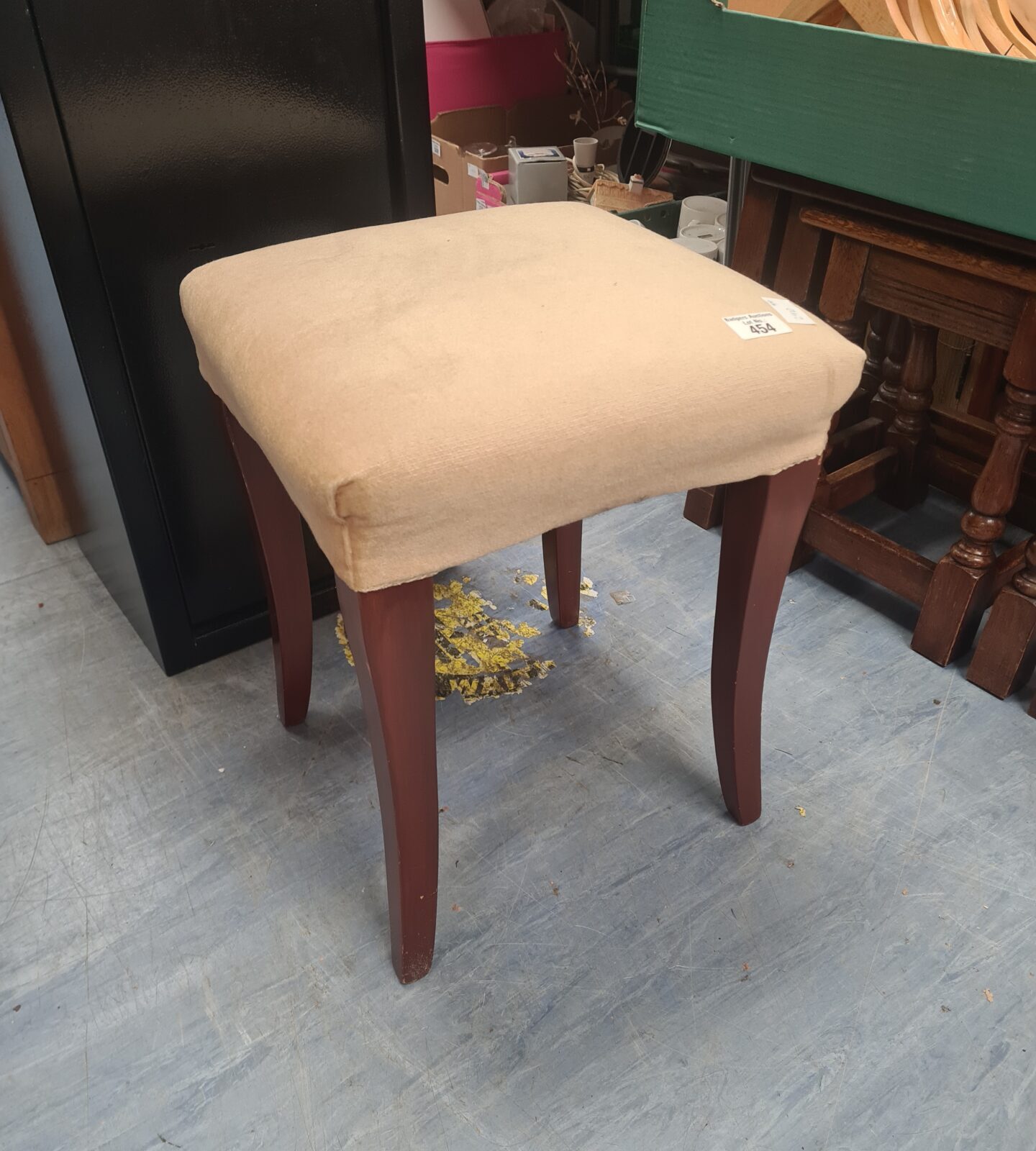 Vintage upholstered footstool with curved wooden legs.