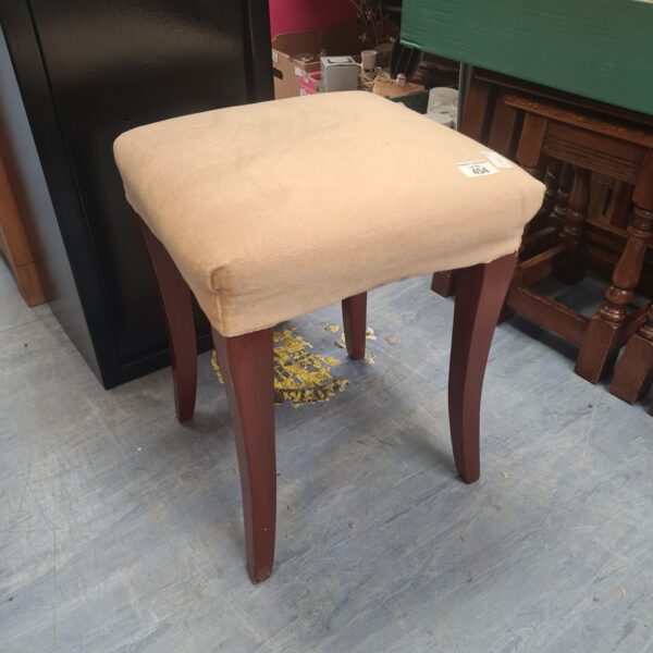 Vintage upholstered footstool with curved wooden legs.