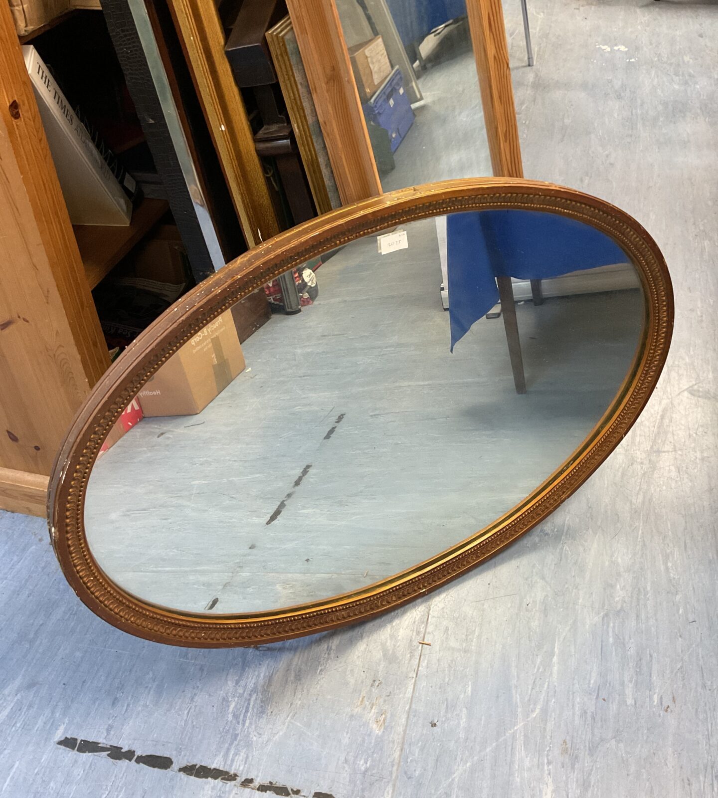 Vintage gilt framed oval mirror measuring 100x65cm for wall decor.