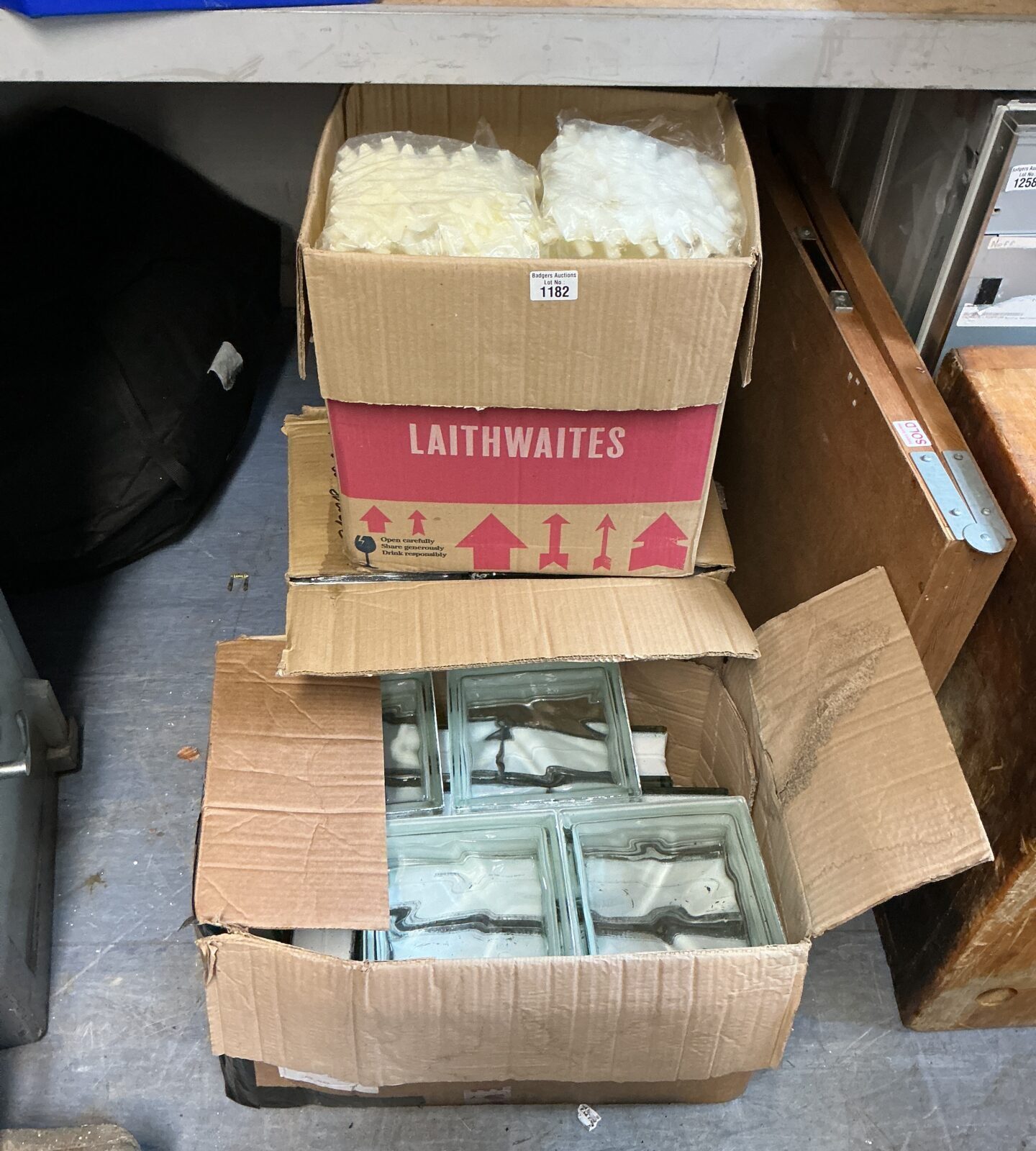 Two boxes of vintage glass bricks with spacers for building projects.