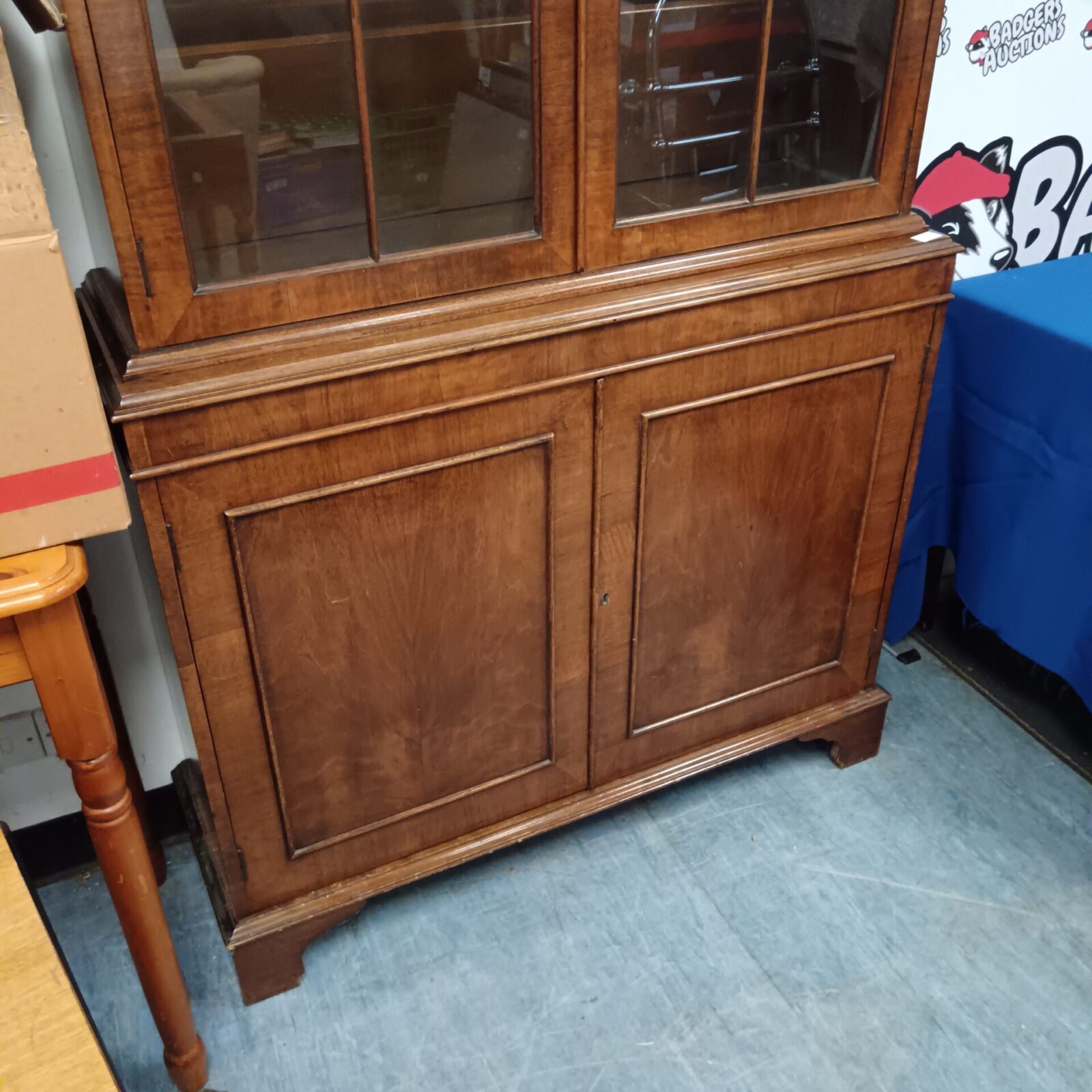 Side view of a vintage wood bookcase with glass doors.