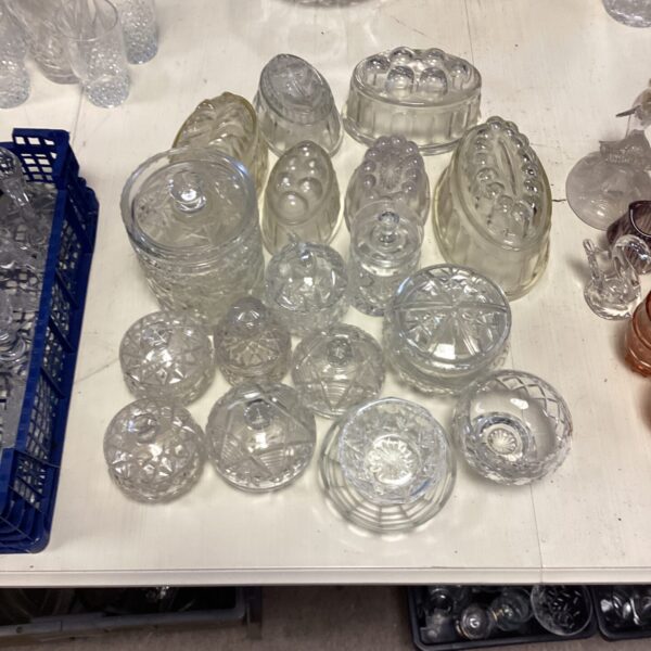 Quantity of vintage glass jelly molds with decorative patterns.