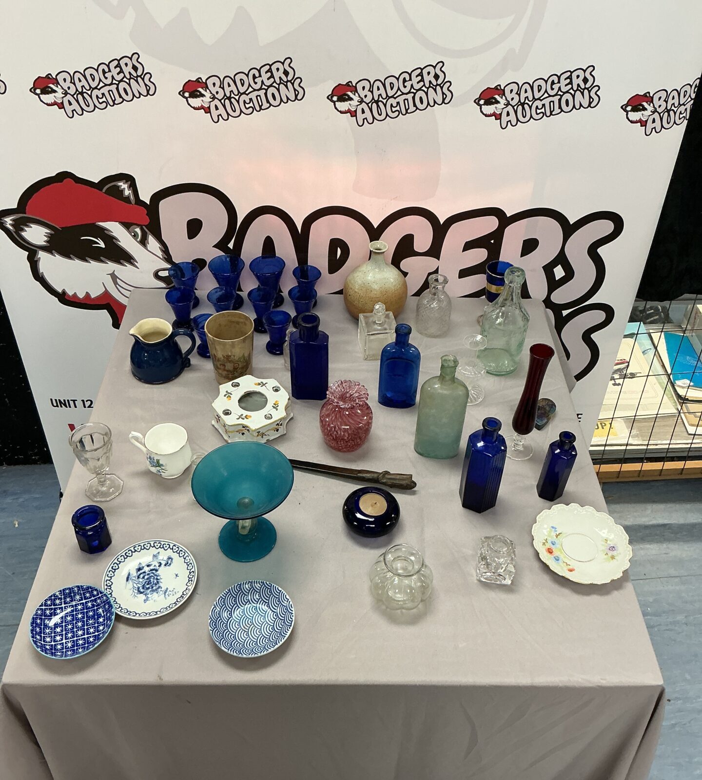 Vintage glassware collection with antique bottles and colourful glass pieces.