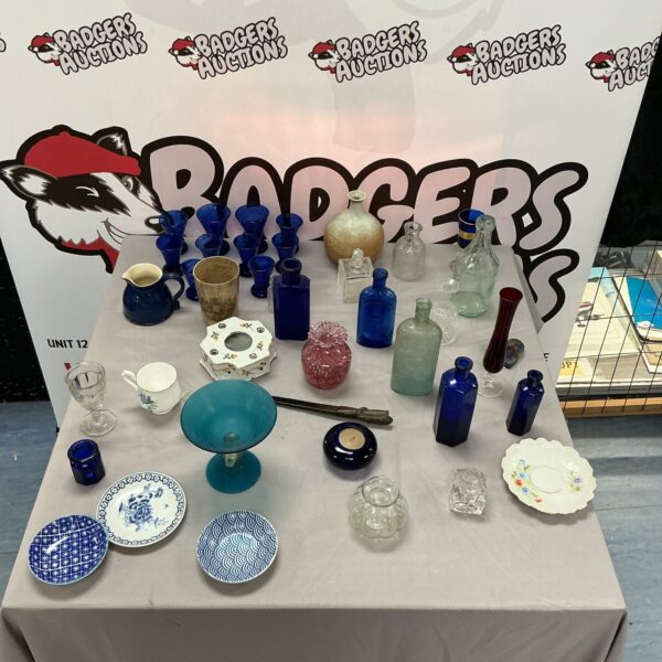 Vintage glassware collection with antique bottles and colourful glass pieces.