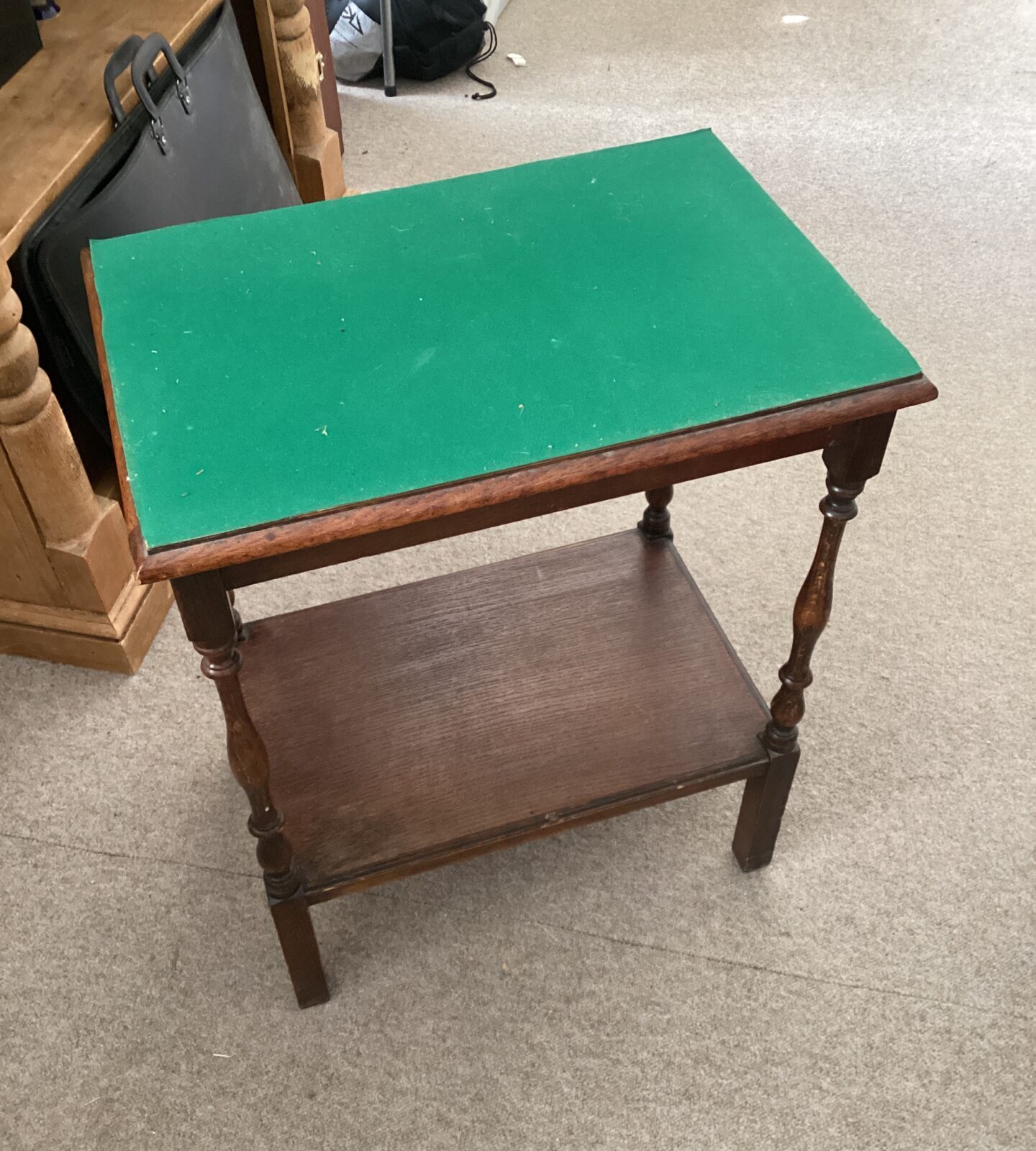 Vintage hall table with green fabric top and turned legs.