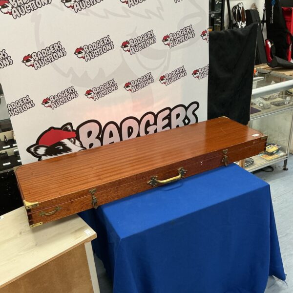 Front view of a vintage wooden gun case with "BADGERS" inscription.