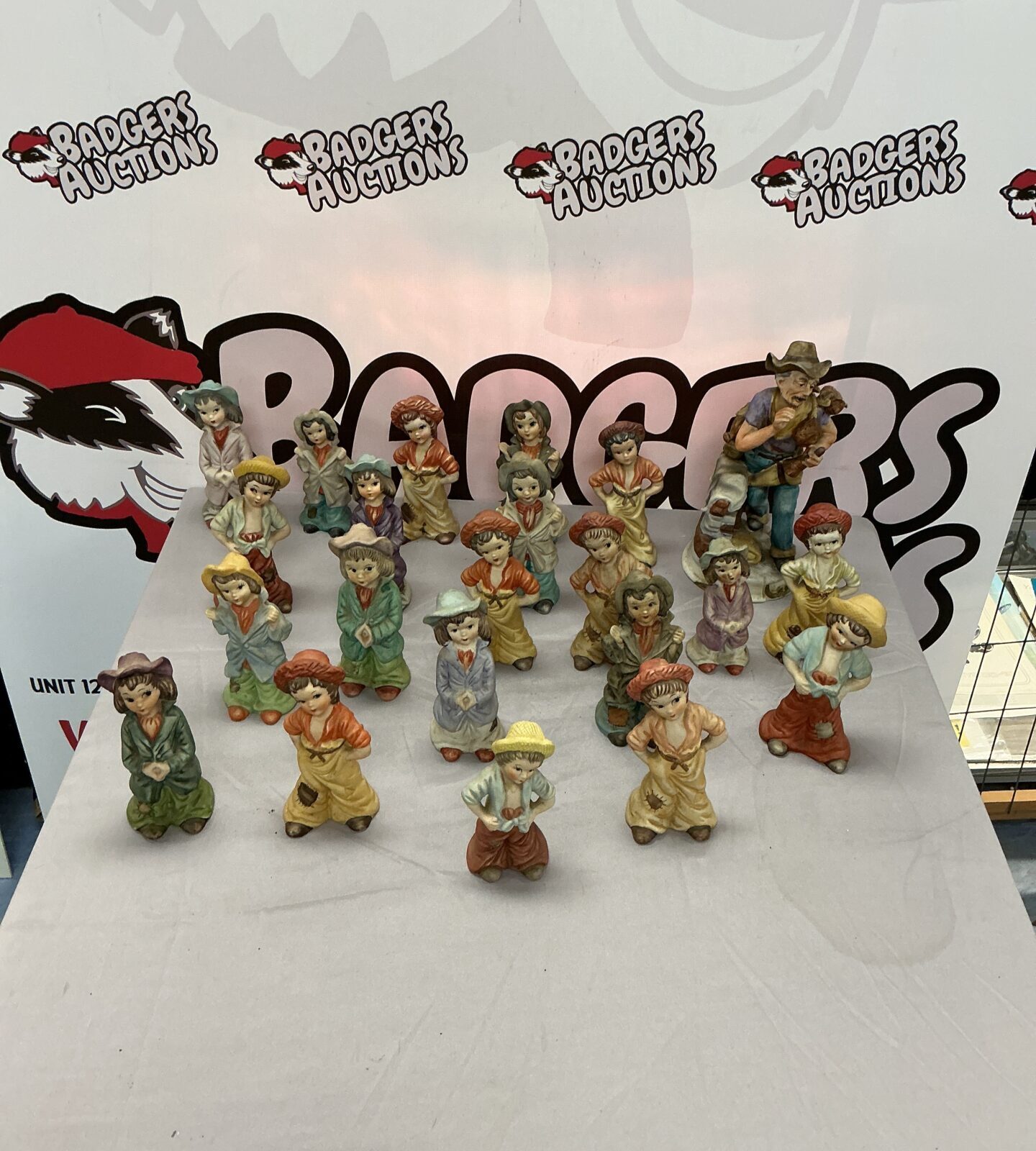 Vintage hand painted ceramic figures including Brinns collectibles on display.