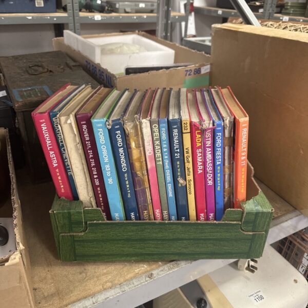 Stack of vintage Haynes manuals for car repair and maintenance.