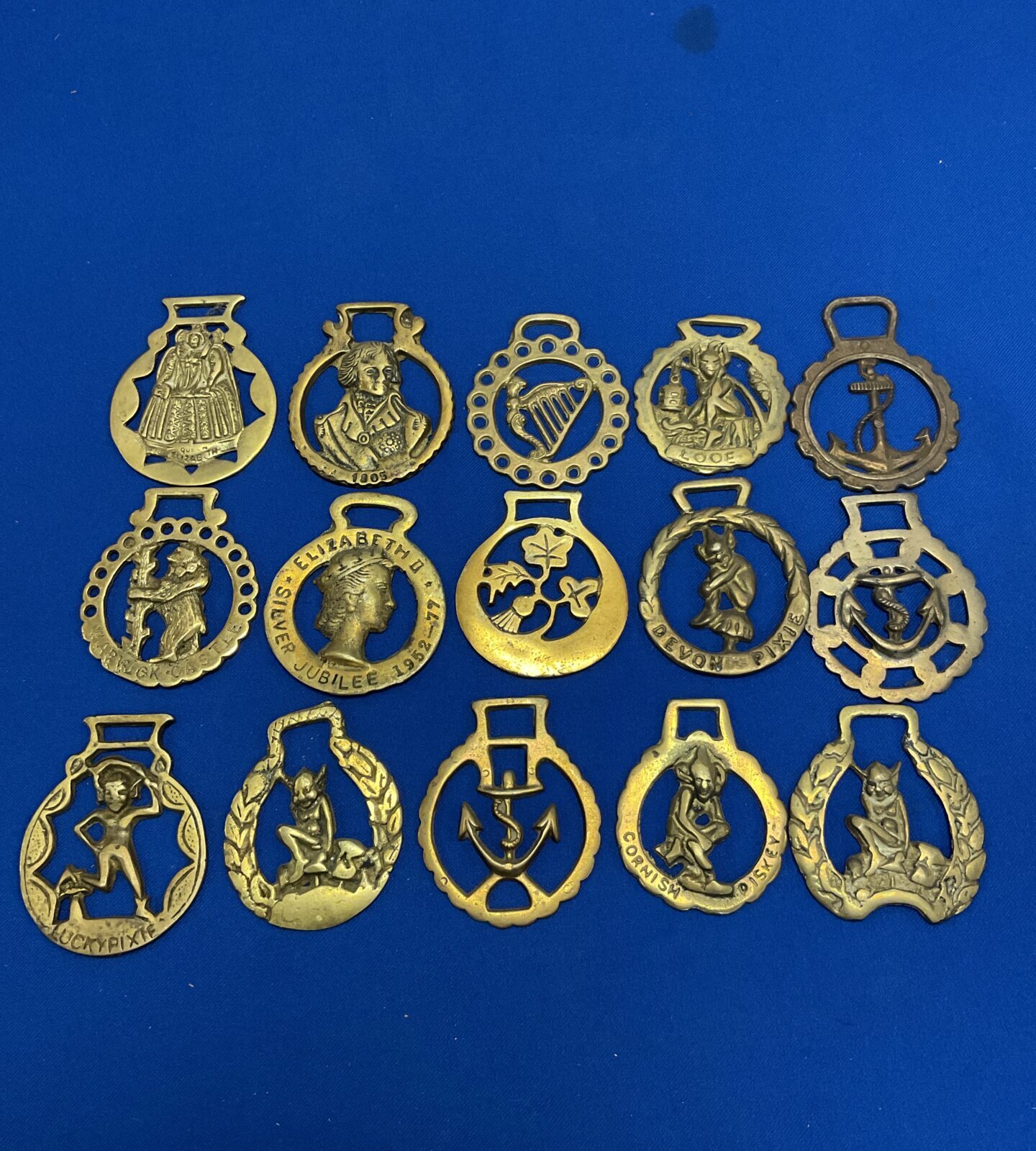 Vintage horse brasses with Irish Pisky designs, collectible equestrian antiques.