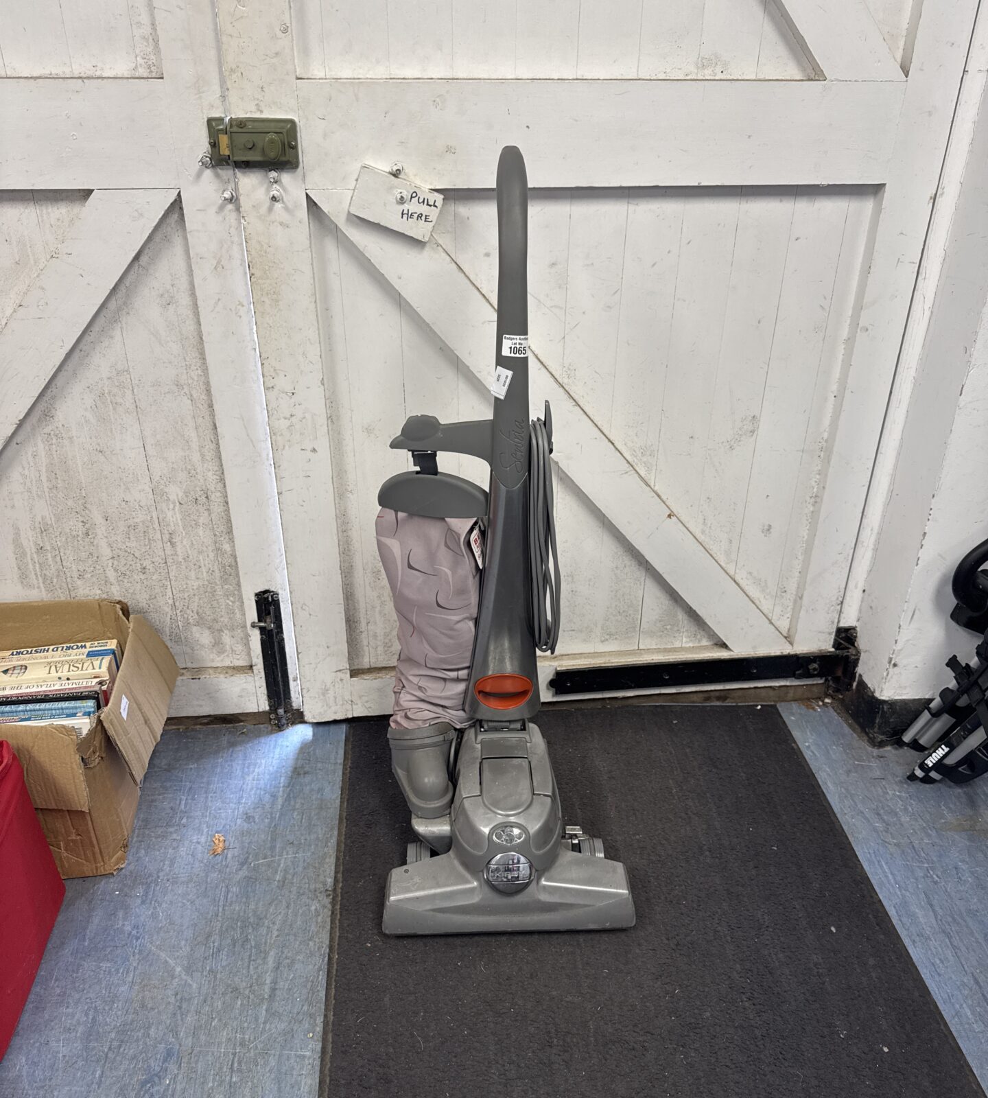 Front view of a vintage Kirby vacuum cleaner with attachments.