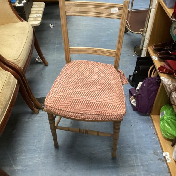 Vintage ladder back chair with patterned seat and spindle legs.
