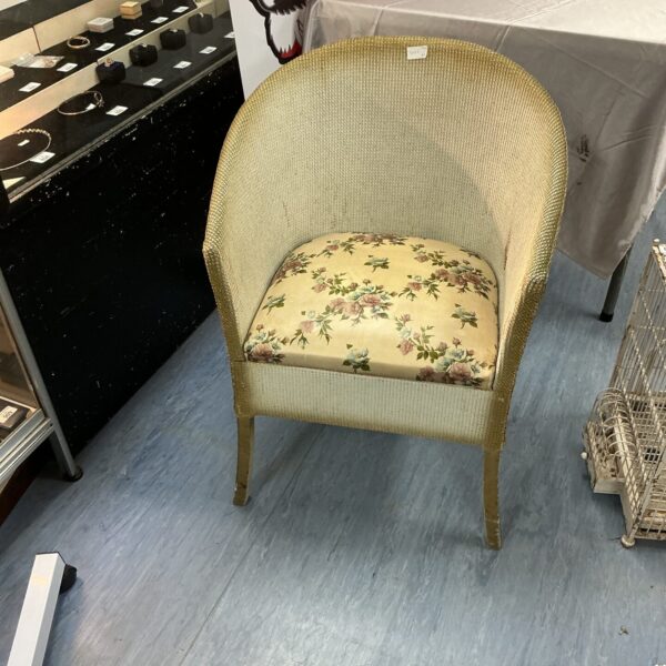 Vintage Lloyd Loom chair with floral upholstery, a charming retro seating option.