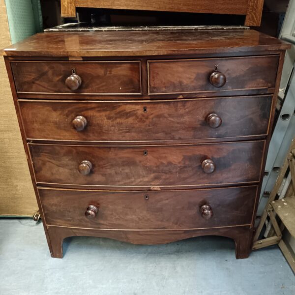 Vintage mahogany chest of drawers with bow front design.