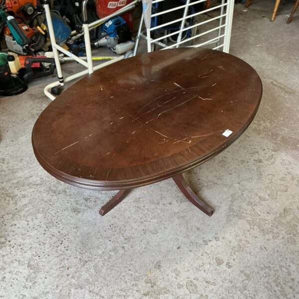 Vintage mahogany coffee table in a workshop setting.