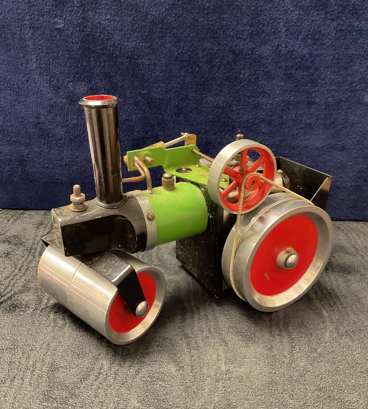 Vintage Mamod steam roller with red wheels and black frame.