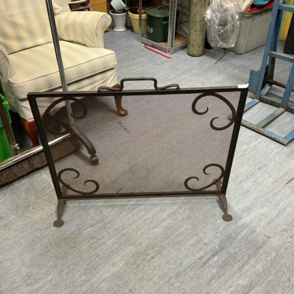 Vintage metal fire guard with decorative pierced design.