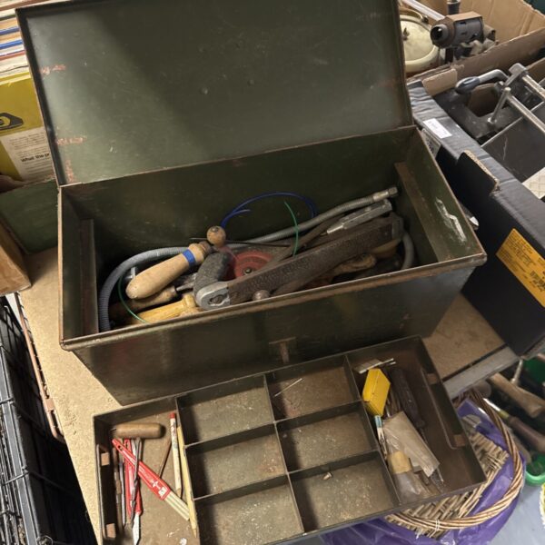 Vintage metal tool box filled with tools for workshop storage.
