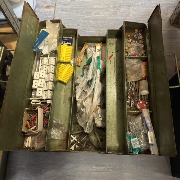 Vintage metal cantilever toolbox filled with various tools and parts.