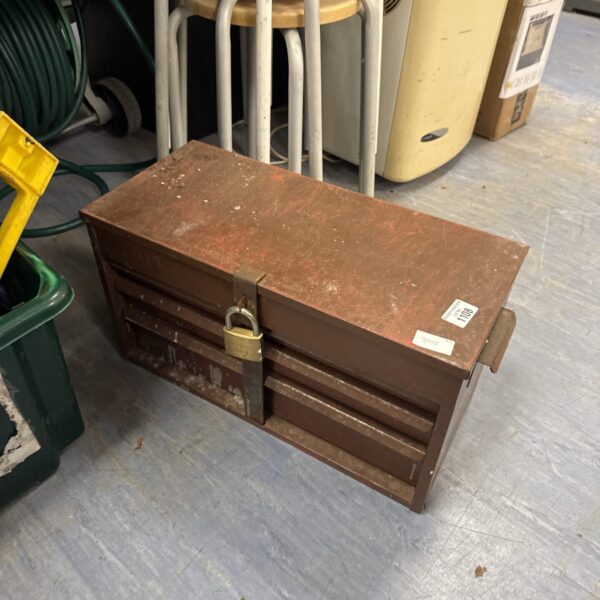 Locked vintage metal toolbox with padlock, antique tool storage.