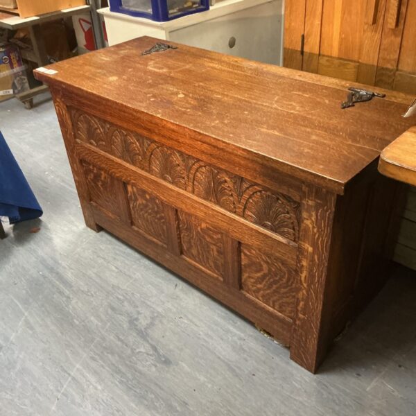 Front view of a vintage oak chest with carved details.
