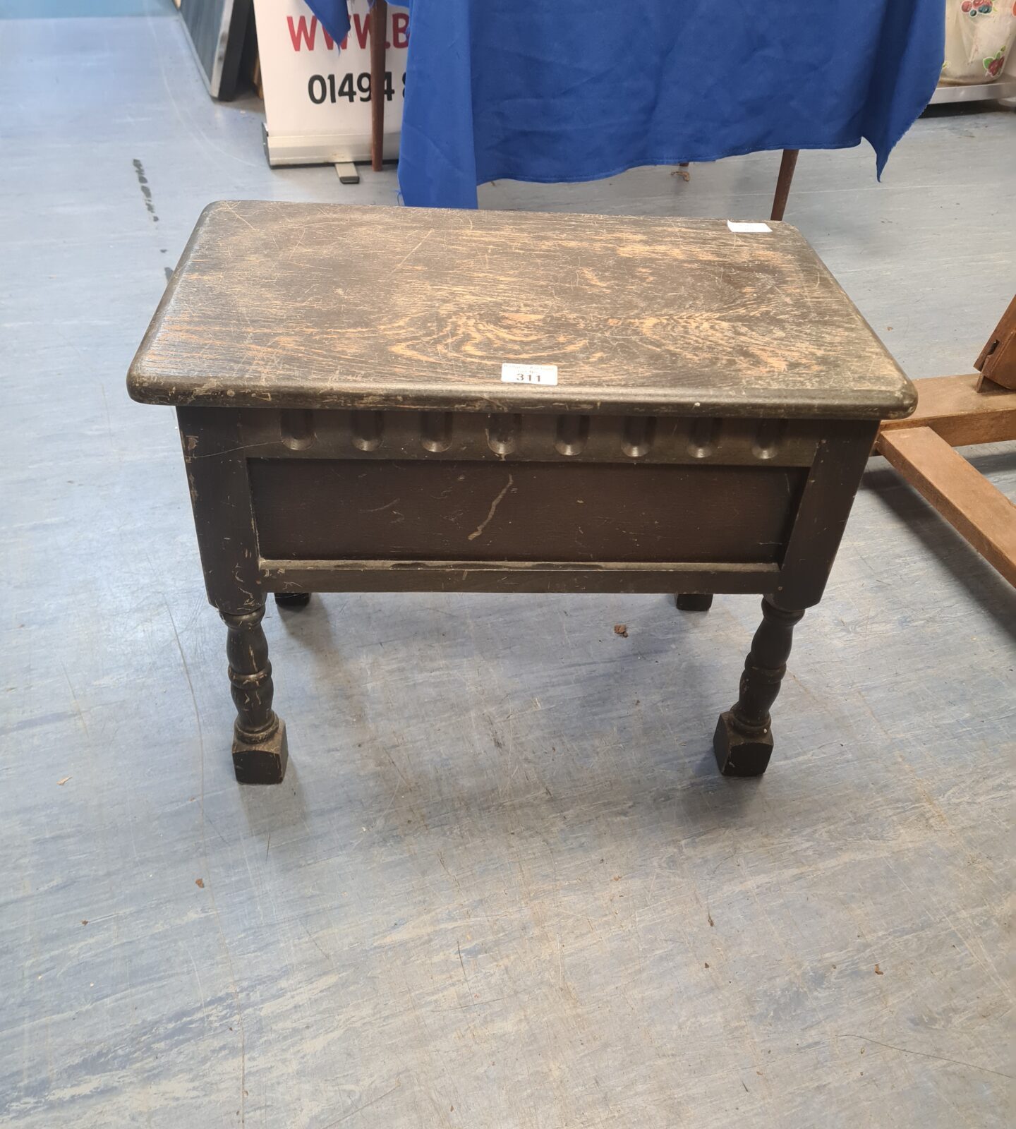 Front view of a vintage oak sewing table with lift-top.