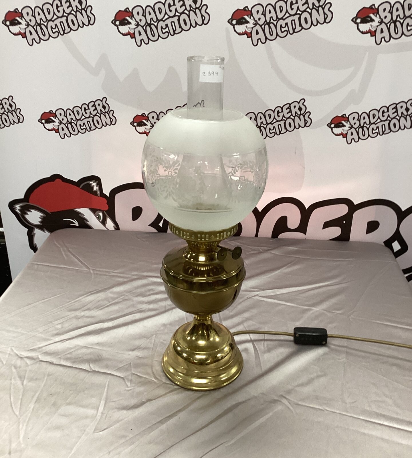Vintage oil lamp repurposed as a table lamp with brass base.