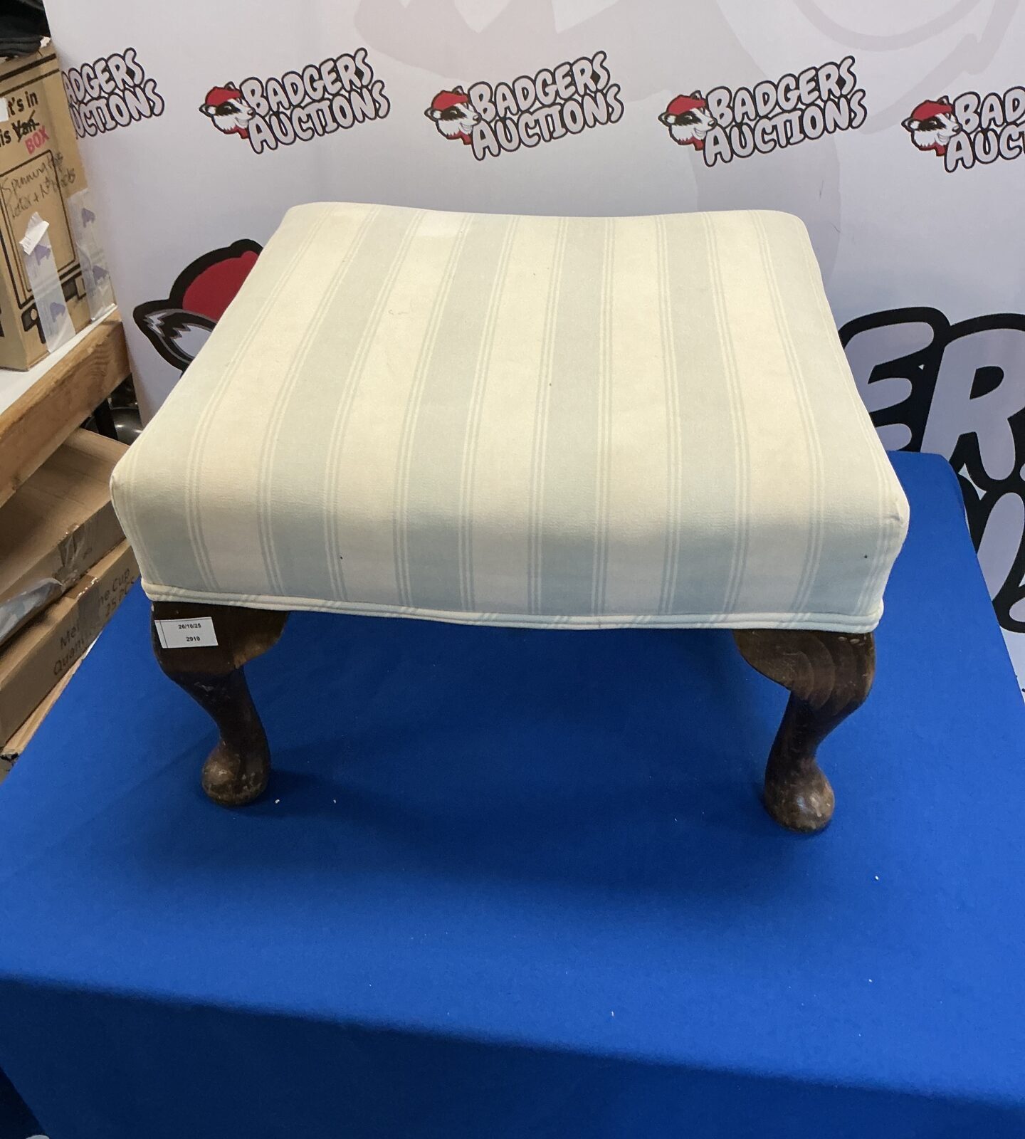 Vintage padded footstool with turned wooden legs for home decor.
