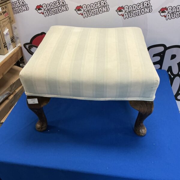 Vintage padded footstool with turned wooden legs for home decor.