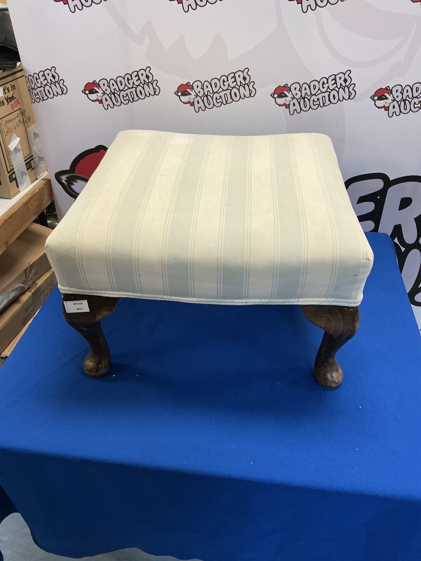 Vintage padded footstool with turned wooden legs for home decor.