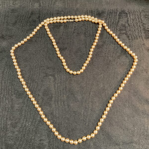 Cream-coloured vintage pearl necklace, 54 inches long.