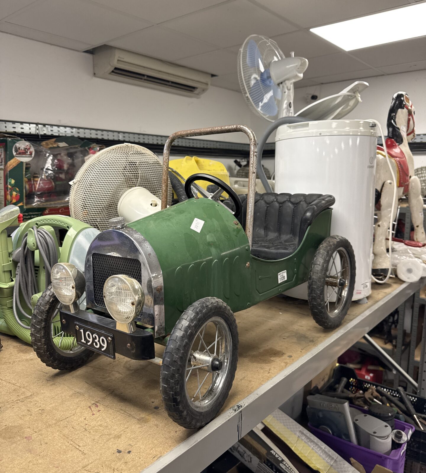 Green vintage pedal car, classic retro toy for collectors.